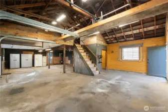 This view showcases the staircase leading to the expansive upper loft and the thoughtful organization of the main level. The combination of updated electrical, insulation, and efficient LED lighting supports year-round usability across multiple work zones.