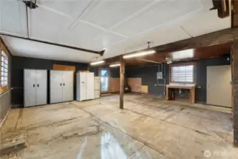 A functional workshop zone featuring built-in storage cabinets, a refrigerator, and hot and cold water service.