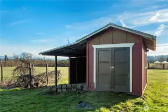 A charming, well-kept shed with classic red siding and a double-door entry, set against open grass and wide-open sky. The generous doors make it easy to move equipment, tools, or outdoor gear in and out, while the simple structure blends naturally into its surroundings. A practical and visually appealing outbuilding that adds character and everyday functionality to the landscape.