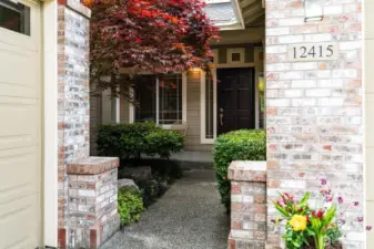 Pleasant walkway lined with mature landscaping offers a welcoming approach.