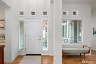 Impressive entrance with two story ceilings and warm, rich hardwood flooring.