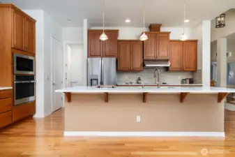 Elongated kitchen island with quartz countertops provides an ideal place for quick meals or serving buffet style.