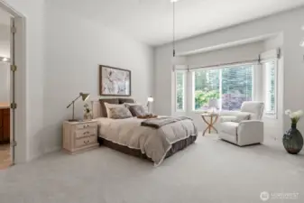 Sizable primary suite with vaulted ceiling and bay window offering a place for a sitting area.