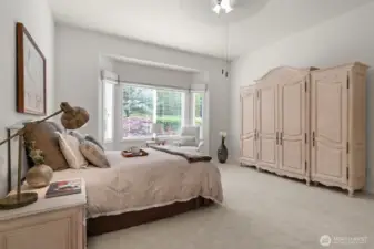 Inviting primary suite, filled with natural light from west facing bay window, creating a warm glow.