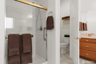 Nicely appointed primary bath with walk-in shower with built-in bench, and private water closet.