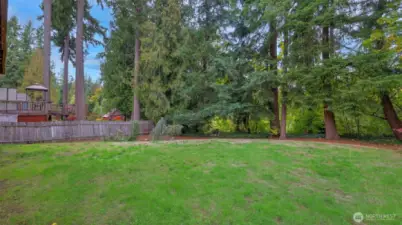 Enjoy outdoor living in this tranquil yard backed by lush greenery and mature trees.
