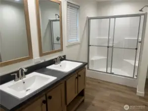 Primary bathroom with double vanity and walk in shower.
