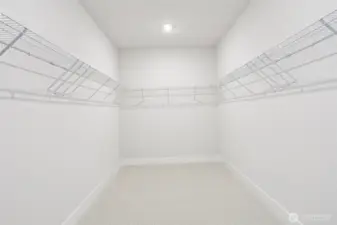 The generous primary bedroom walk-in closet provides desirable storage options.  Photo is of similar home-details & finishes will vary-ask site agent for details