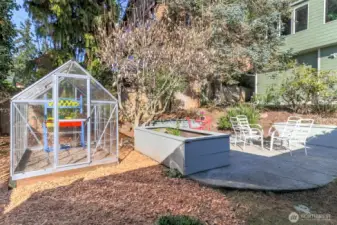Firepit area, green house and raised flower beds