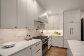 Kitchen with built in refrigerator, custom hood for the range.