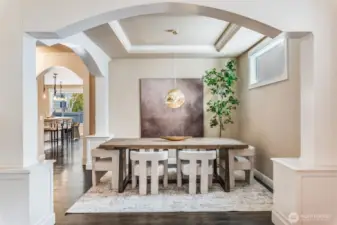 Beautifully framed formal dining room w/coffered ceilings & arched columns, perfect for stylish entertaining.