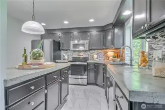 Remodeled kitchen with tile backsplash and concrete countertops