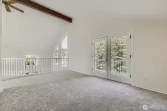 Primary suite and balcony with windows overlooking the trees or river views