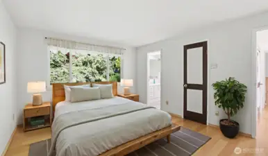 Upstairs offers a primary retreat with hardwood floors, walk-in closet, lush views to the backyard, and a private 3/4 bath en suite. (Virtually Staged)