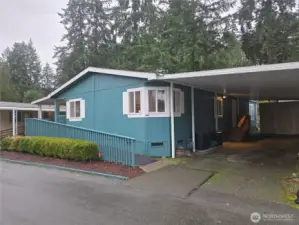 Front with carport and, in back, is large storage shed