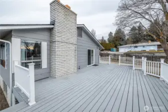Imagine hosting or relaxing on this spacious deck under the shade trees