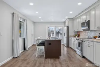 Large island and slider out to deck for awesome parties or BBQs - you know everyone hangs out in the kitchen! Exterior door to the left goes to back driveway area.