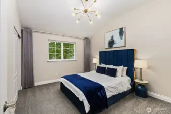 Elegant vaulted bedroom with designer lighting, plush carpeting, and a calming palette that exudes comfort and style.