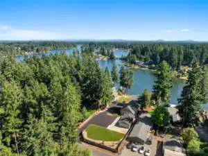 Welcome to your waterfront compound. The newly paved driveway opens up to a spacious area that checks every box, from the 4-car garage to the flat grassy lawn that’s ready for anything from playsets to pergolas. Surrounded by mature trees and lake views that stretch for days, this is the kind of property that gives you privacy without isolation. Pride of ownership echoes from every home in view, but this one stands apart with space, access, and flexibility to use it exactly how you want.