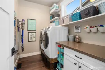 Say goodbye to laundry day blues. The high-efficiency washer and dryer sit on pedestals for easy access, while a folding counter doubles as a workspace for crafts or wrapping. Shelving keeps supplies neat, and an upper window brings in natural light and ventilation .