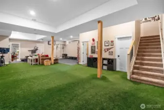 This basement is a sporty dream with astro turf flooring perfect for recreation, kicking around a ball, or even practicing your putting game. There’s a dedicated workout area with padded flooring, carpeted stairs for quiet access, and soaring 10-foot ceilings that keep it feeling spacious. Plus, a walk-in storage room keeps clutter out of sight. Bonus: direct access to the 1-bedroom basement Airbnb, with flexible connection options if you want to open the doors.
