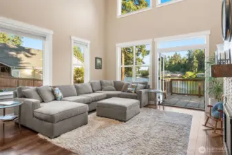 Unit B’s living room stuns with soaring two-story vaulted ceilings and walls of windows showcasing stunning lake views. Glass French doors open to a spacious upper balcony deck, perfect for taking it all in. A gas fireplace with a wood mantle adds cozy charm to this light-filled space that’s all about bright, airy living. A loft in the living room would make additional square footage with awesome lake views if a railing and ladder were added.