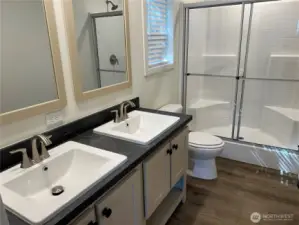 Primary bathroom with double vanities and walk in shower.