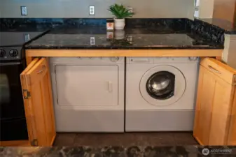 Washer and dryer under counter in kitchen.