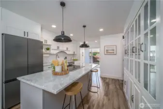 The kitchen features an eat-in island, subway tile backsplash, stainless appliances, granite countertops, farmhouse sink, and expansive cabinetry.