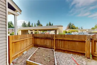 This sunny spot is fully fenced with raised garden beds—perfect for growing herbs and vegetables!