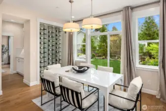 Amazing full-size dining area right by kitchen, glass-enclosed wine display, sliders open up to the serene back yard.