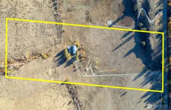 The property is flanked by a natural rock outcropping and protected public land. (Approximate boundary in yellow)