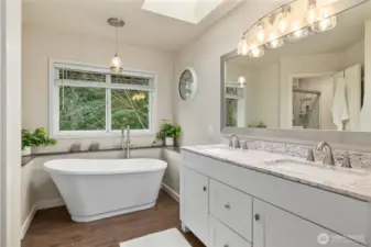 Luxurious standalone bathtub and double sink vanity off the primary bedroom.