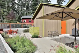 Outdoor bench seating area with forged fire pit hard piped to propane.  Exterior door leads to garage.