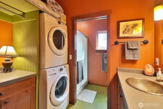 Lower level 3/4 bath with laundry and storage cabinet and high shelf.  Pretty marmoleum vinyl floors in baths.