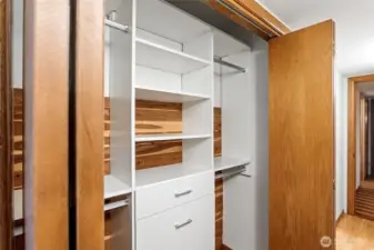SECOND closet in primary with built in drawers and shelves, plus some cedar planks.