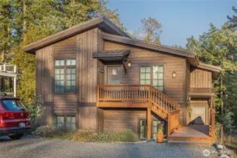 Front exterior highlighting the home’s modern Northwest architecture, warm wood siding, and private upper-level entry, blending beautifully with the natural island surroundings.