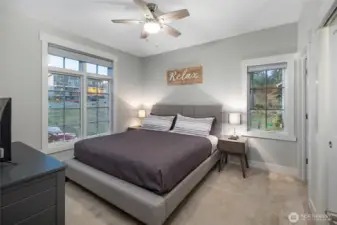 Bright and peaceful primary bedroom featuring large windows that frame the surrounding island landscape and bring in abundant natural light.