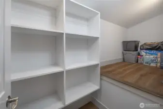 Spacious pantry with built-in shelving and countertop workspace provides excellent storage and organization for kitchen essentials.