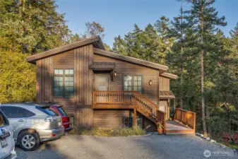 Well-maintained condo exterior surrounded by mature trees, offering low-maintenance living just minutes from Friday Harbor’s marina, shops, and restaurants.