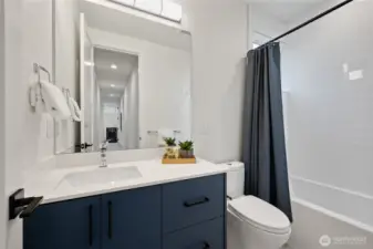 Full size guest bath with good-vanity, soaking tub and completely tiled shower surround.