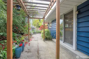 Heading the other direction from the sliding door off the dining area, the walkway leads to a charming side patio.