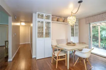 The dining area features built-in seating and cabinetry, providing comfort and extra space to showcase your favorite pieces. A convenient hallway leads to the bedrooms and the main full bath.