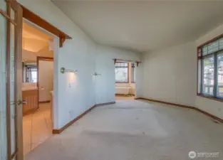 ENTERING THROUGH THE FRENCH DOORS INTO THE PRIMARY BEDROOM AND THE HUGE WRAP AROUND BATH!