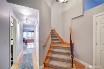 Hardwood stairway with inlaid carpet leads to bedrooms
