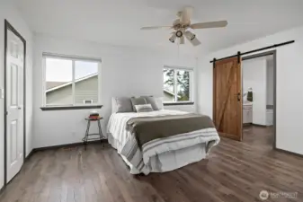 Primary bedroom with sliding barn door into ensuite bathroom.