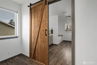 Sliding barn door from primary bedroom into ensuite bathroom.