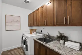 The expansive laundry room is a haven for organization, boasting ample storage and included appliances, making daily chores a breeze.