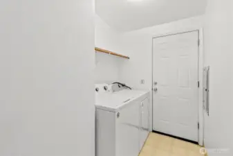 Laundry room off of the kitchen with door leading to the side yard