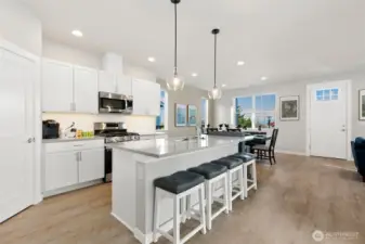 Spacious Kitchen Island with Stool Seating Space. White Cabinets, Undermounted lighting.